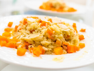 Risotto with carrot and parmesan on white background