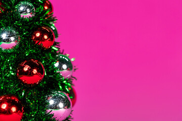 Artificial Christmas tree and details on it. Purple background.