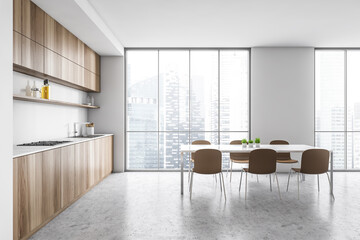 White and wooden minimalist kitchen with chairs and table near window