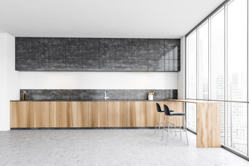 Black and wooden minimalist kitchen with counter and bar chairs near window