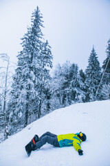 man laying on snow with snowboard copy space