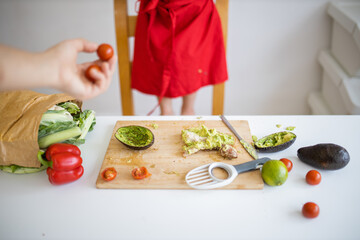 Female hand giving small tomatoes to a little girl at a table