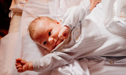 an infant is lying on a dressing table in the Church. the ordinance of baptism.
