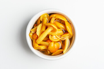 Canned mushrooms in a bowl on a white background. Top view.