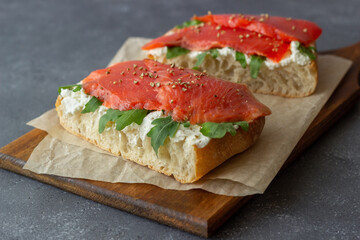 Open sandwiches with salmon, arugula and white cheese. Healthy eating.