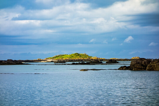Small rocky islands on the horizon in the archipelago of Iles de Chausey. Brittany, France.