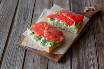Open sandwiches with salmon, arugula and white cheese. Healthy eating.