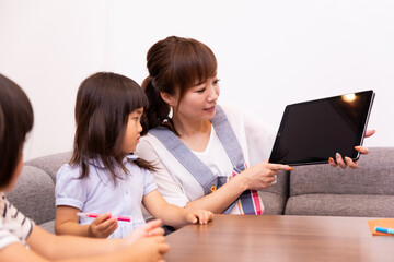 タブレットをみる子供と女性
