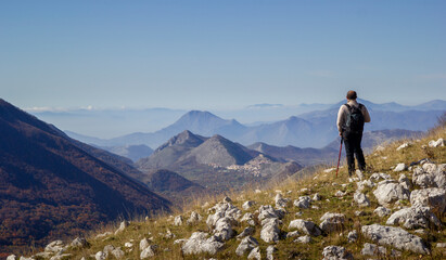 hiker on the top of a mountain in matese park and Letino in the background on Apennines in italy