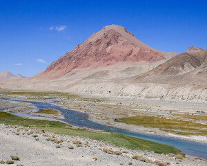 Scenic pastel color mountain and river landscape along high-altitude Pamir Highway between Murghab and Ak Baital pass, Gorno-Badakhshan, Tajikistan