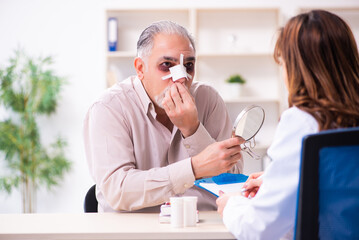 Old man visiting young female doctor for plastic surgery