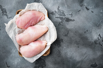 Chicken uncooked meat on grey background, flat lay  with copy space