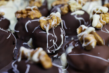 Close up of homemade black and white christmas chocolate pralines filled with walnuts, marzipan and...