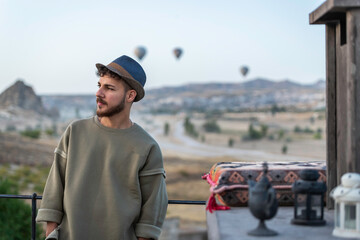 Young tourist man watching a hot air balloon tour in Cappadocia.