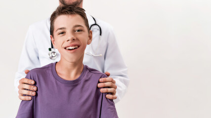 Cropped shot of male doctor helping teenaged disabled boy with cerebral palsy, posing isolated over white background