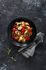 Grilled vegetables with mushrooms in a plate on a dark background