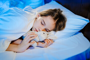 The pretty teen girl naps with a plush toy, sees a pleasant sleep.