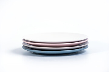 Stack of four colorful empty plates isolated on white background, side view. Navy Blue, Grey, Pink and 

White empty plates collection