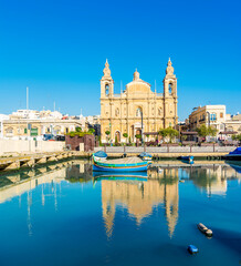 The Msida (Imsida) harbor view with beautiful mirror reflection of boats and Parish Churc  in west of Valletta, Malta.
