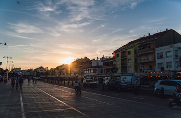 beautiful sunset in the fishing town of Cabrils. People walk along the embankment and cyclists ride.