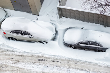 Top aerail view of apartment office building parking lot with many cars covered by snow stucked...