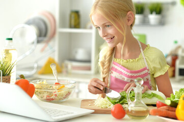 Obraz na płótnie Canvas Girl preparing delicious fresh salad in kitchen