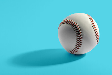 Baseball with long shadow on blue background