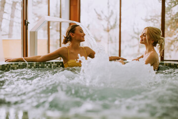 Young women relaxing in the whirlpool bathtub at the poolside