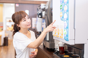 ドリンクバーで飲み物を選ぶ女性
