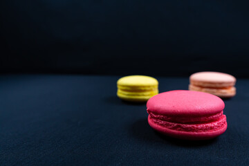 Obraz na płótnie Canvas Colourful stack of macaroons isolated on plain black background. Copyspace