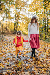 mother and child walking in autumn park