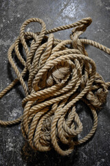 A coil of jute rope on a concrete background