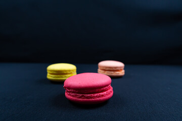 Obraz na płótnie Canvas Colourful stack of macaroons isolated on plain black background. Copyspace