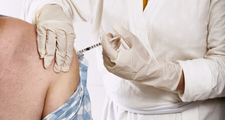 Close-up of coronavirus vaccine injection to patients with high risk of contagion. Public health campaign