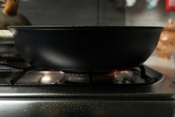 frying pan at the white gas stove over the white background.