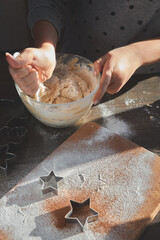 Making ginger cookie dough. The concept of a feast in the house, a family dinner. New Year traditions concept and cooking process. Cookies on dark brown wooden table. Family making