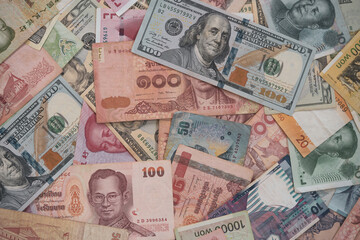 Currency exchange and forex investment concept, Closeup variety banknote around the world such as dollar Yuan Baht Won and Piso.