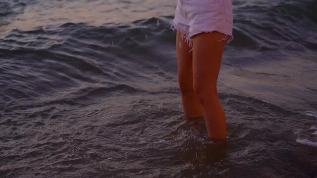 Young woman playing splashing water in tropical beach ocean in sunset evening. Beautiful sexy fit girl playful in the sea during travel vacation - HD Quality Footage
