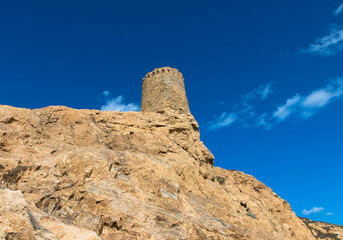 Fototapeta premium Genoese Tower on the top of the stone island Pietra, rocky promontory of Ile Rousse, a famous city from Corsica, France