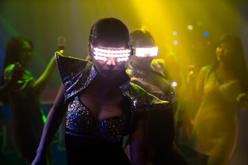 Techno dancer in night club dancing to the beat of music from DJ . EDM new year night party and...