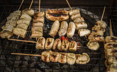 Fototapeta premium The bananas are skewered and grilled over a wood charcoal fire.
