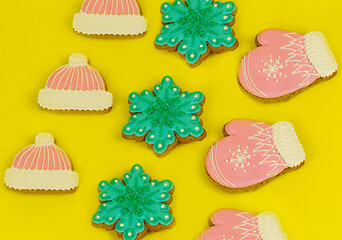 Christmas gingerbread covered with bright icing on a yellow uniform background