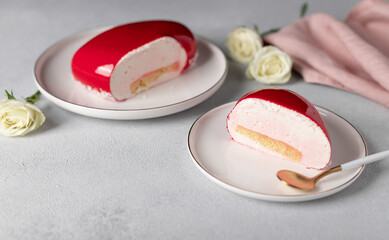 slice of mousse cake on white plate on gray background with white roses. Concept Valentines Day, Mothers Day, Birthday. soft focus