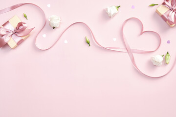 Ribbon in shape of heart with gift boxes and rose flowers on pink background. Happy Valentines day, Mothers day, birthday concept. Romantic flat lay composition. - obrazy, fototapety, plakaty