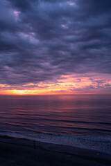 Fototapeta na wymiar Beautiful Sunrise over the Ocean with Dramatic Clouds