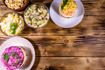 Set of festive mayonnaise salads on wooden table. Top view