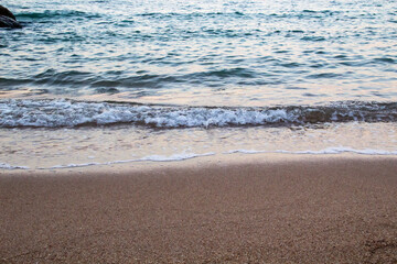 The beach with sea waves running on the sand. Beautiful view on the waves