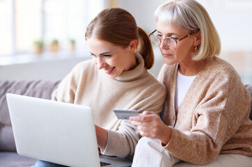 Mother and daughter shopping online together.