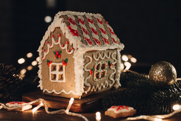 Scandinavian hygge styled Christmas composition. Cozy winter homely scene with gingerbread house for Holidays. Christmas cookies.