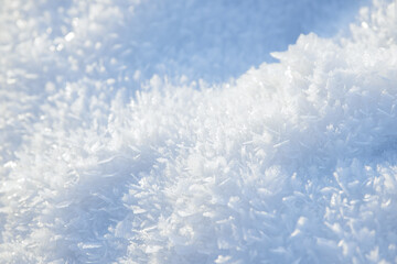 Hoarfrost background texture. Fresh ice and snow winter backdrop with snowflakes and mounds. Seasonal wallpaper. Frozen water geometrical shapes and figures. Cold weather atmospheric precipitation.